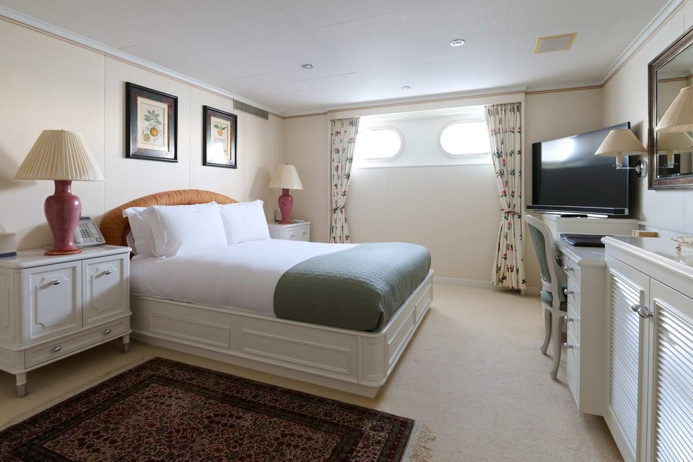 a bedroom with a bed and a television aboard LADY BEATRICE Yacht for Sale