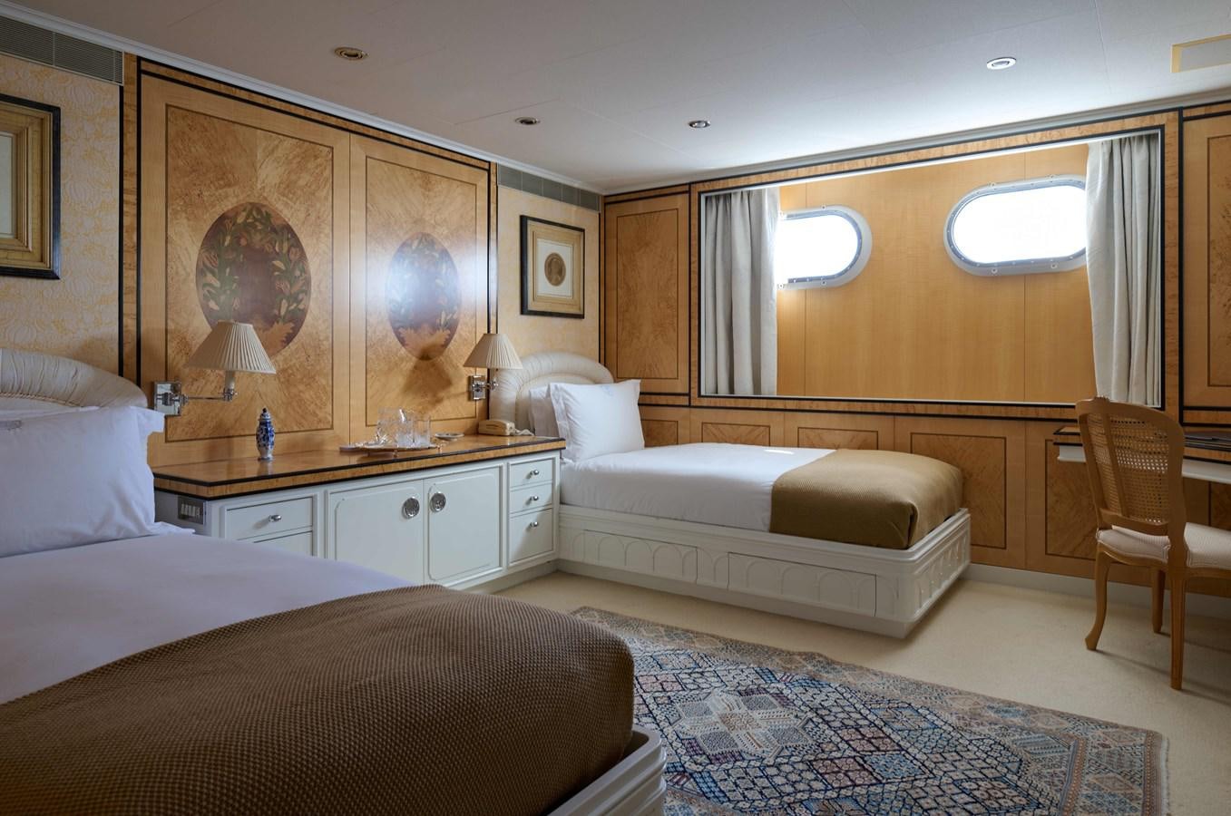 a room with a bed and a chair aboard LADY BEATRICE Yacht for Sale