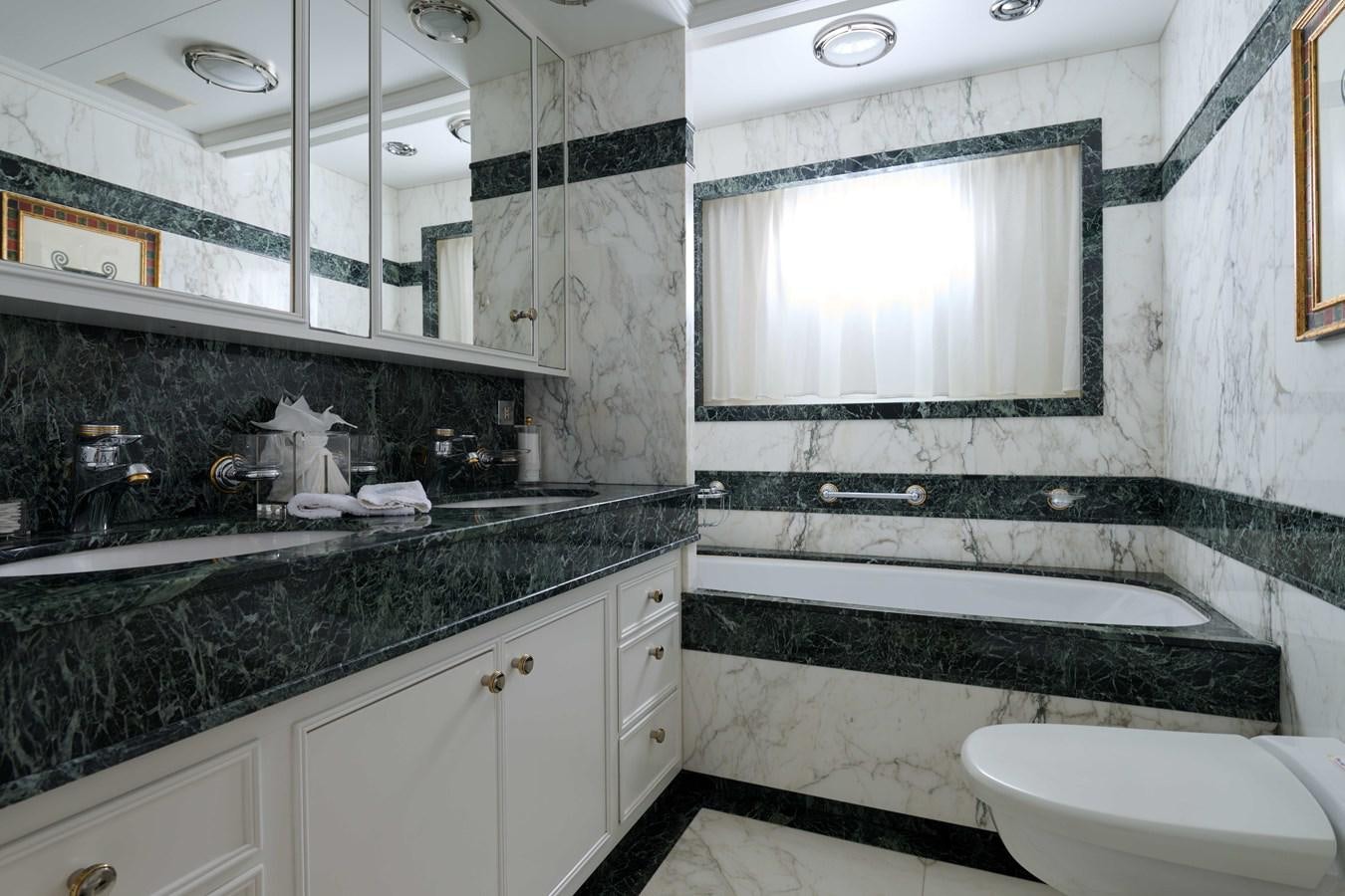 a bathroom with a tub sink and a mirror aboard LADY BEATRICE Yacht for Sale