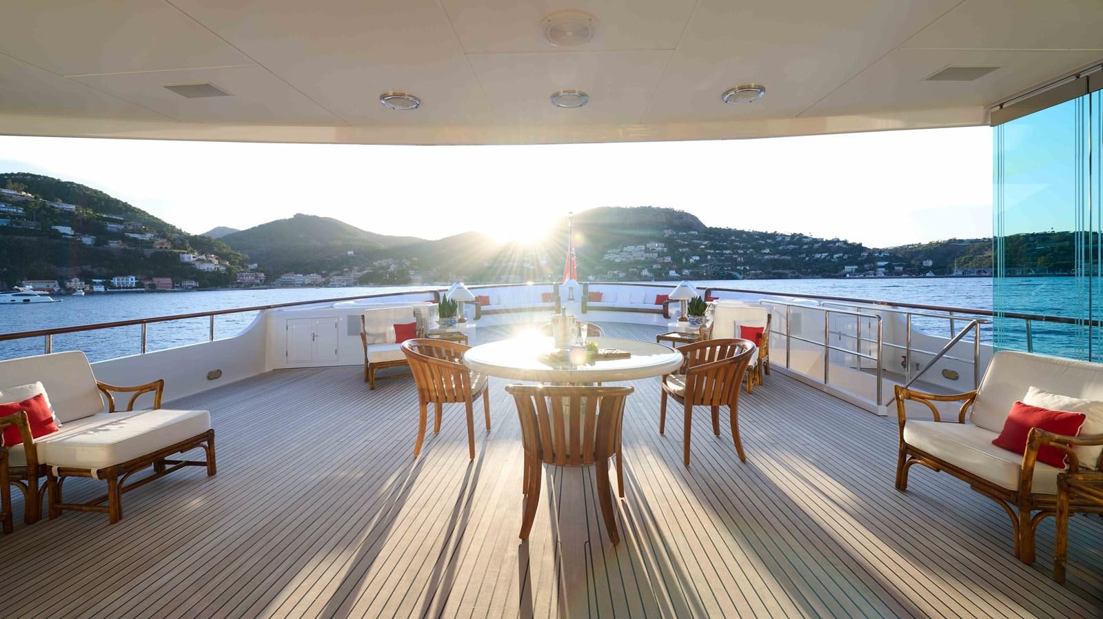a large room with a table and chairs and a view of the water aboard LADY BEATRICE Yacht for Sale