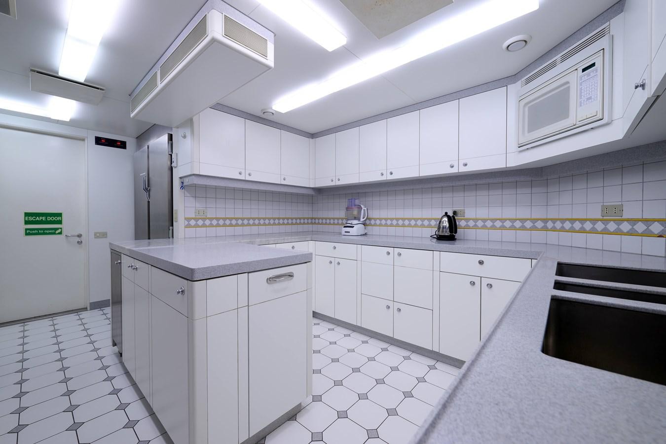 a kitchen with white cabinets aboard LADY BEATRICE Yacht for Sale