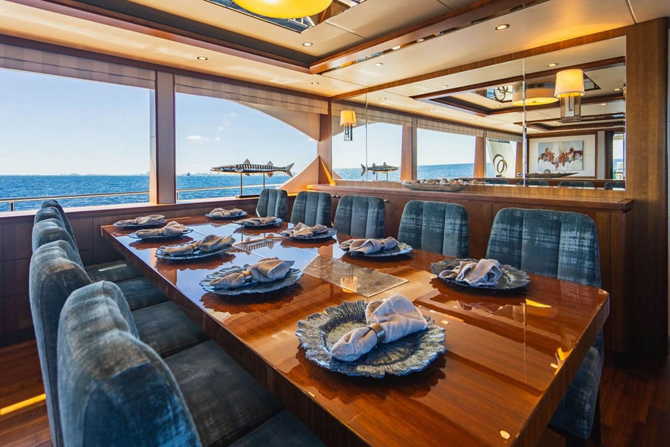 a large dining table with a view of the ocean aboard FAR NIENTE Yacht for Sale