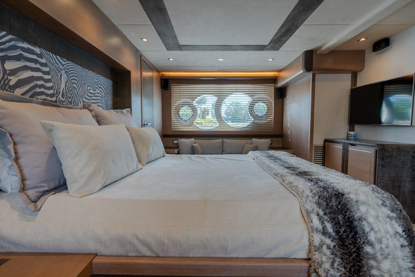 a bed with a painting on the wall aboard PANDA Yacht for Sale