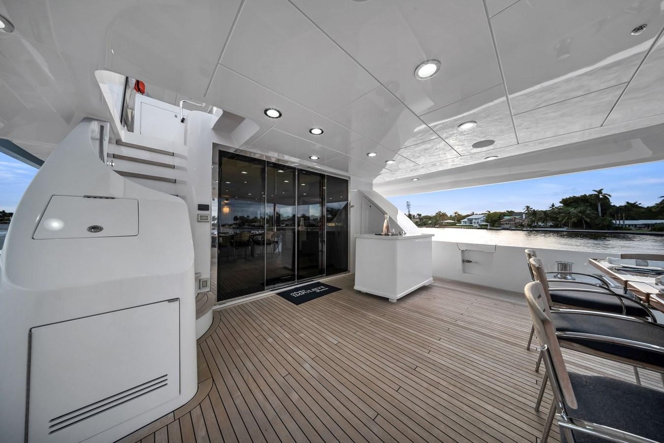 a room with a large glass door and a deck with a view of the ocean aboard ANOTHER IMPULSIVE DECISION Yacht for Sale