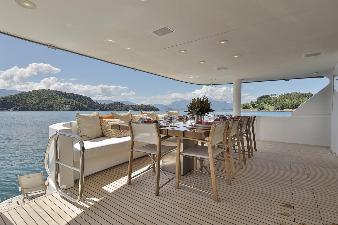 a deck with a table and chairs on it aboard PAPA-GOLFE Yacht for Sale