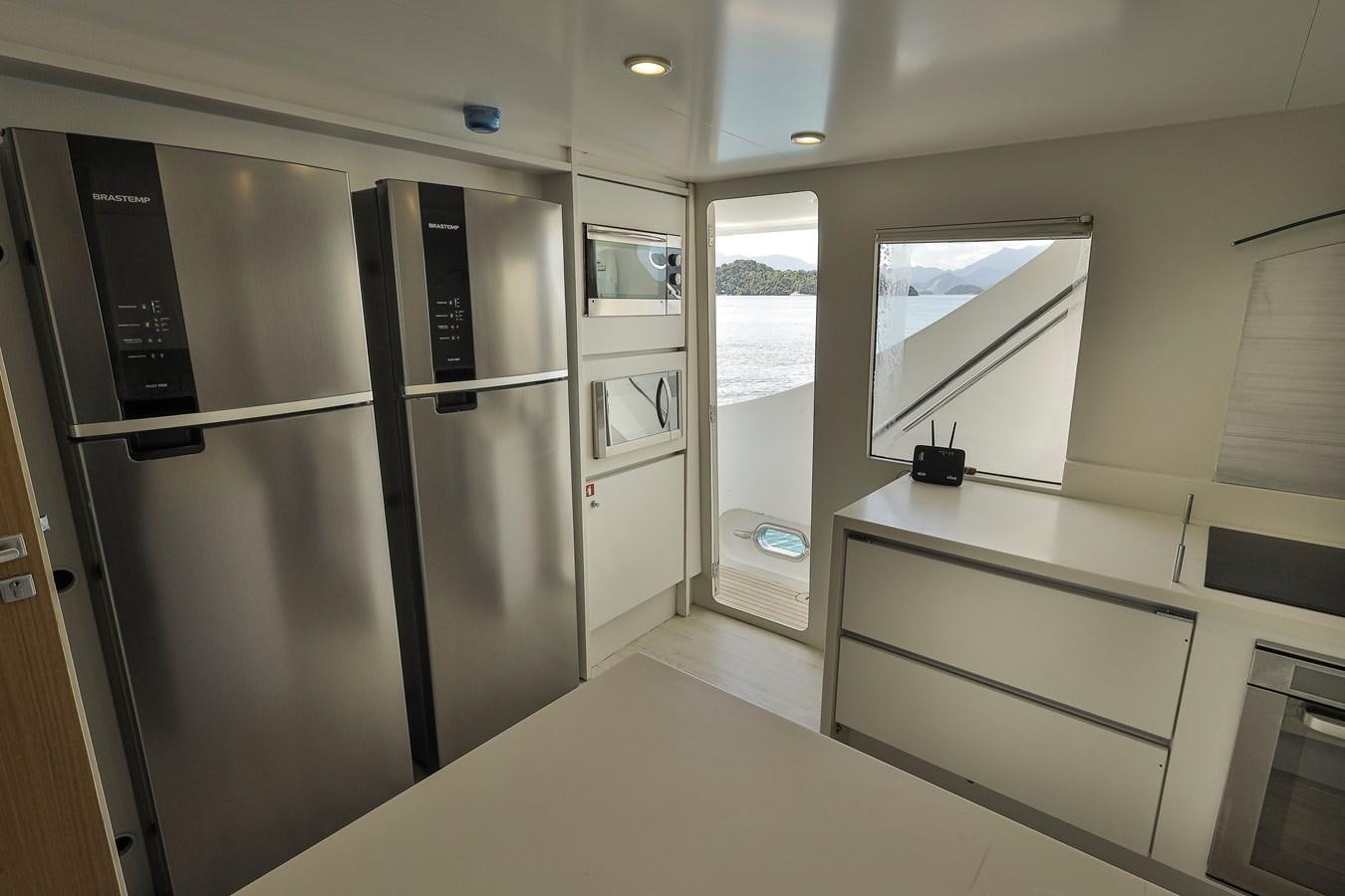 a kitchen with a refrigerator and cabinets aboard PAPA-GOLFE Yacht for Sale