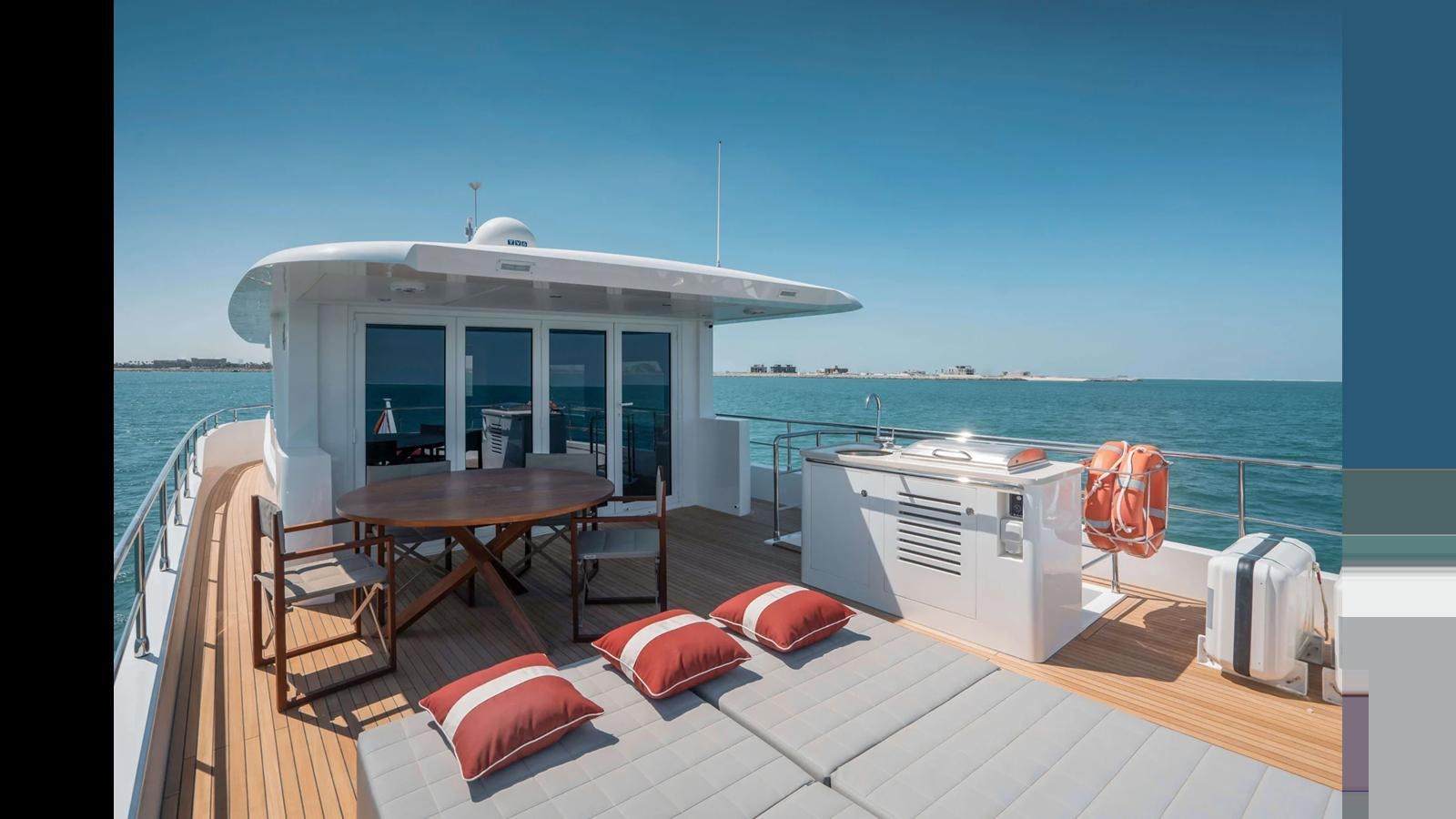 a deck with a table and chairs on it aboard NOMAD 70 SUV Yacht for Sale