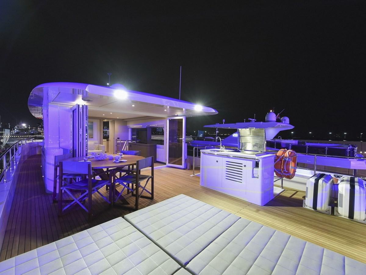 a swimming pool with a table and chairs and a bar aboard NOMAD 70 SUV Yacht for Sale