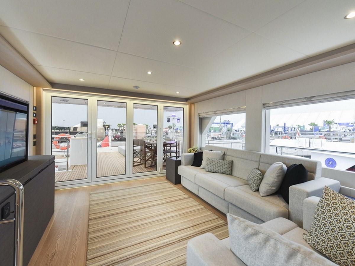 a living room with a large window aboard NOMAD 70 SUV Yacht for Sale