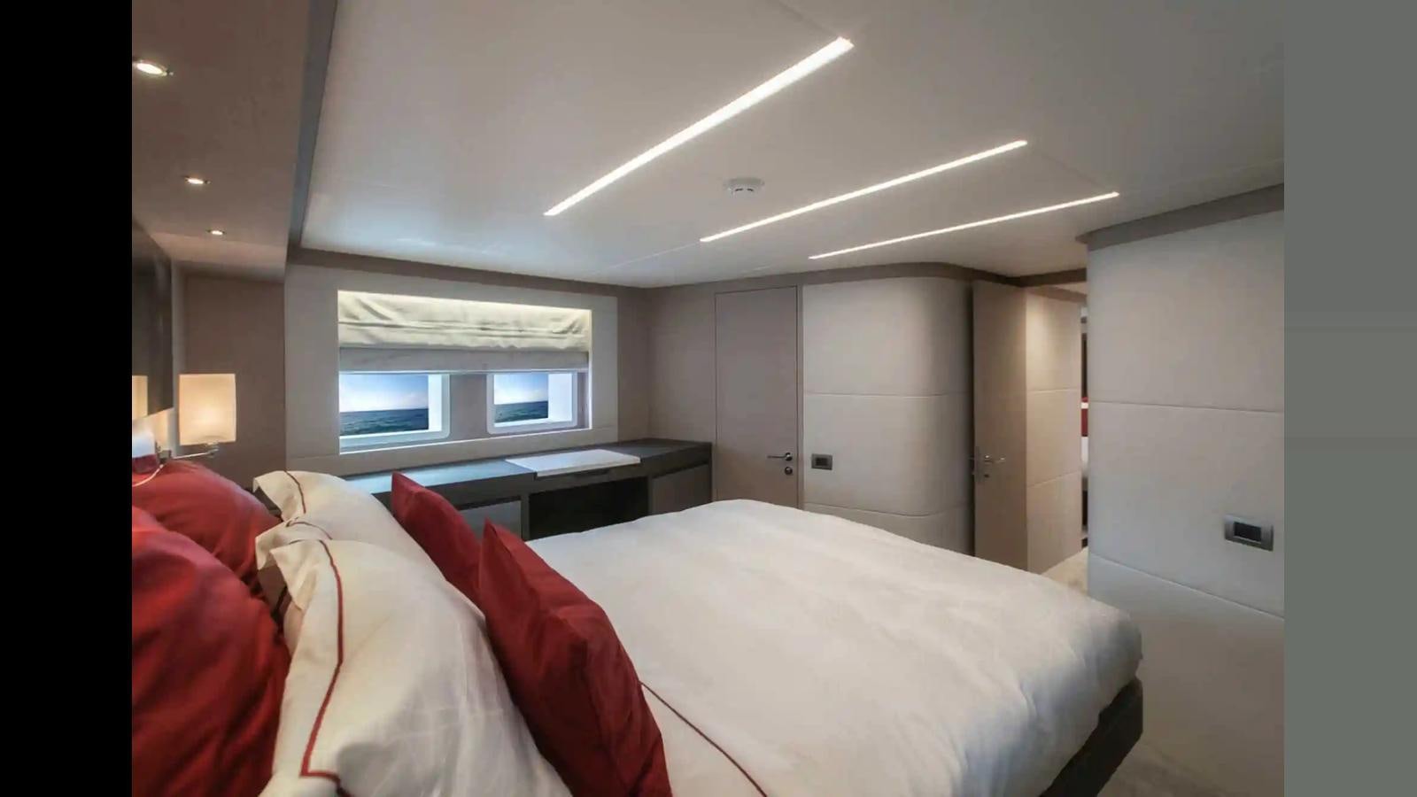 a bedroom with a bed and a desk aboard NOMAD 70 SUV Yacht for Sale