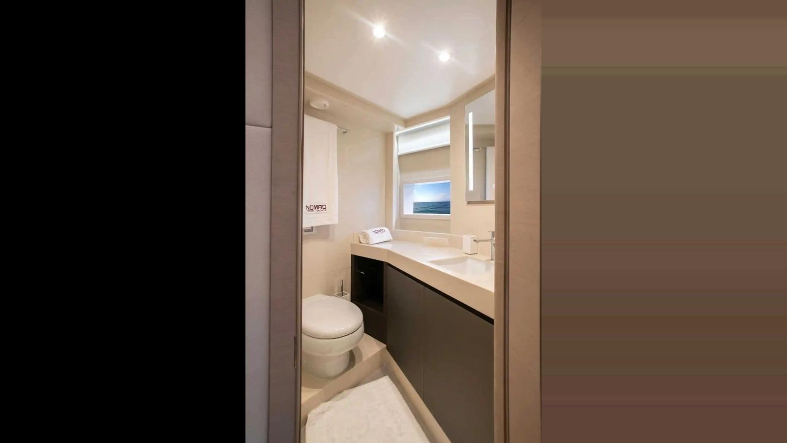a bathroom with a toilet and a sink aboard NOMAD 70 SUV Yacht for Sale