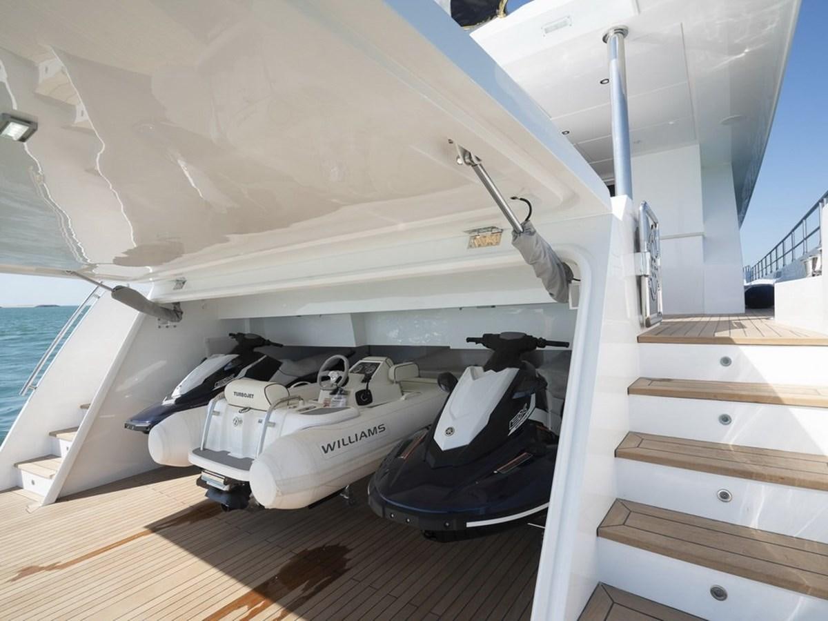 a white boat with a black and white boat on the deck aboard NOMAD 95 SUV Yacht for Sale