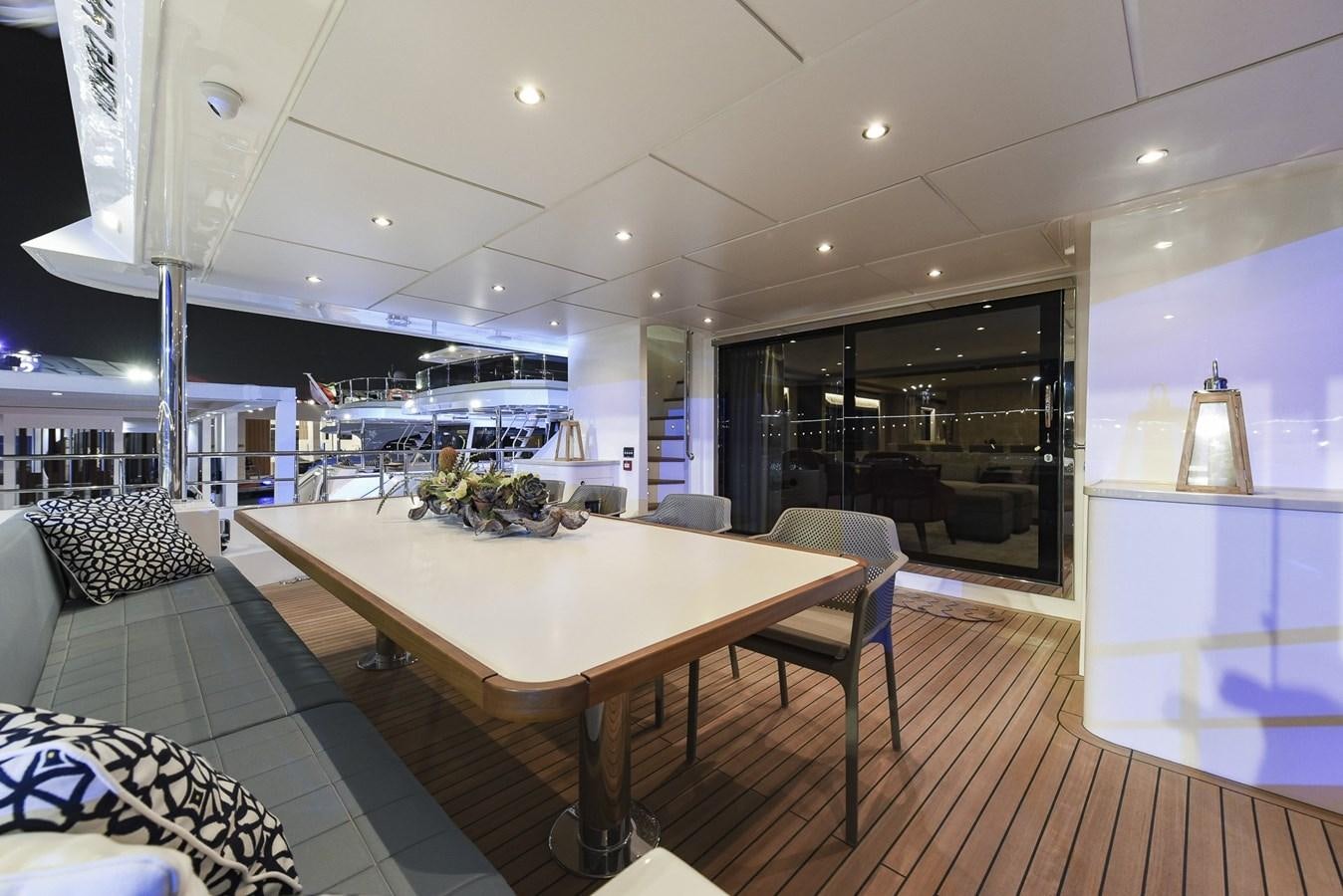 a large room with a table and chairs aboard NOMAD 95 SUV Yacht for Sale