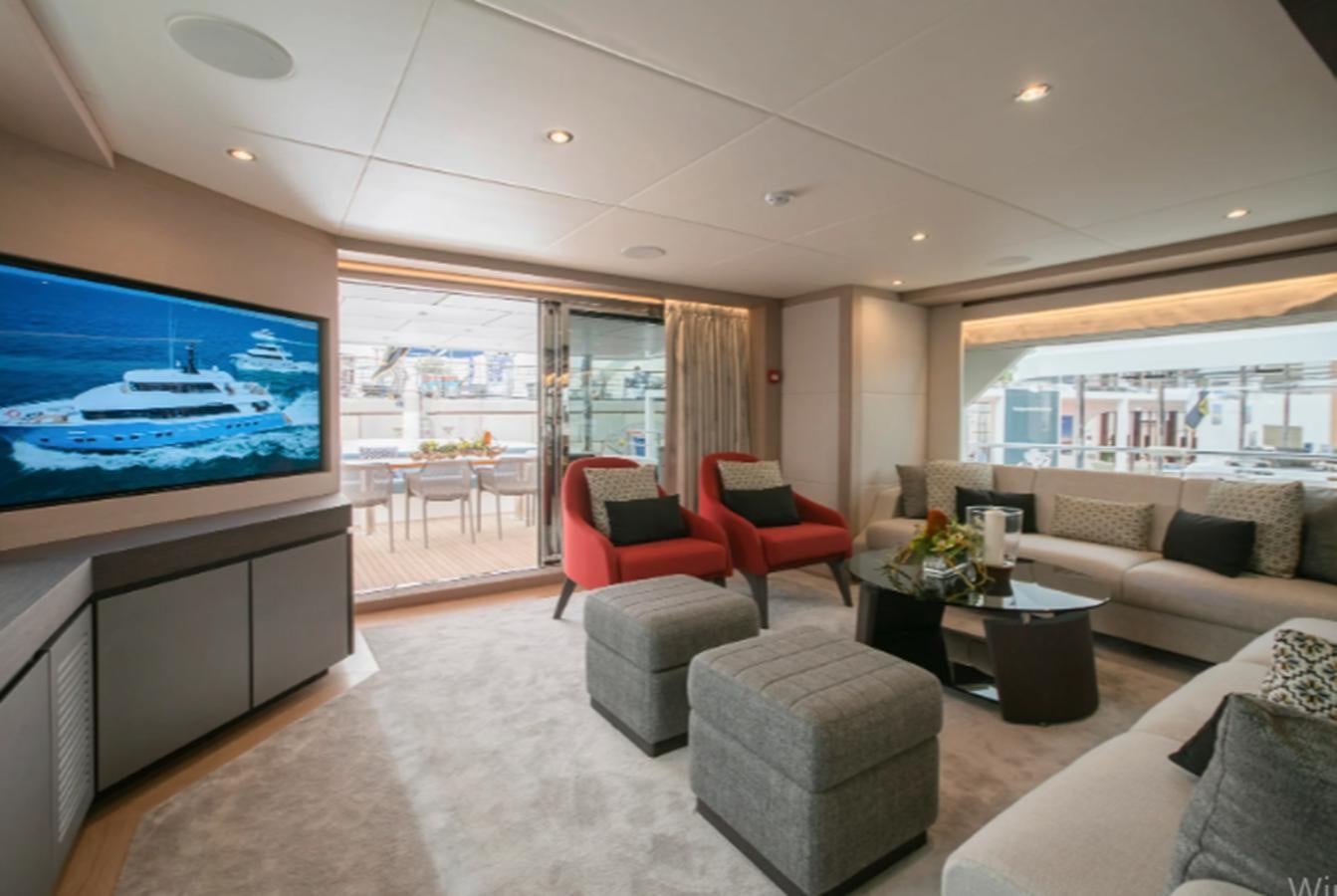 a living room with a large screen aboard NOMAD 95 SUV Yacht for Sale