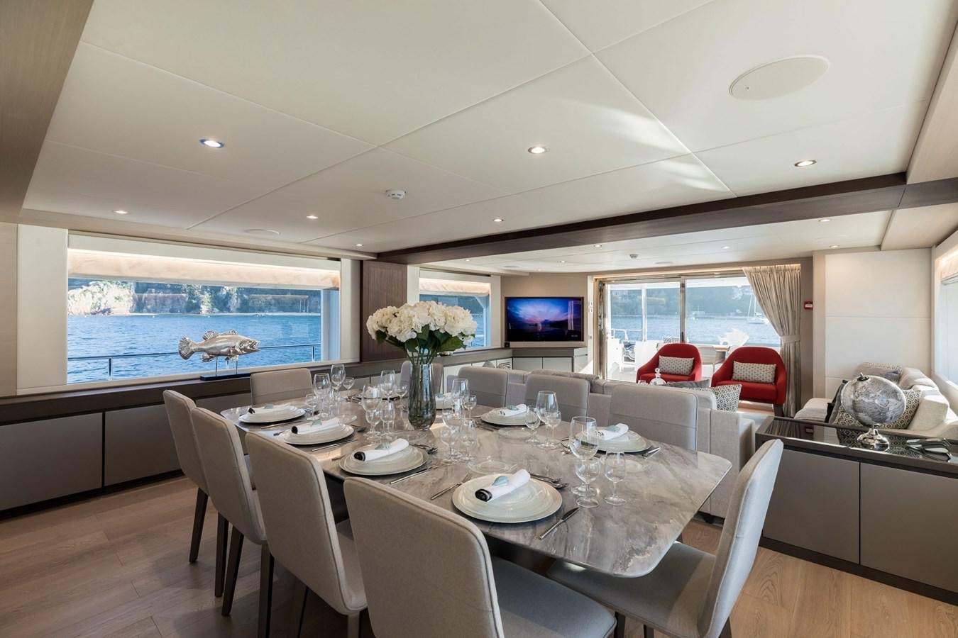 a dining room with a table set for a meal aboard NOMAD 95 SUV Yacht for Sale