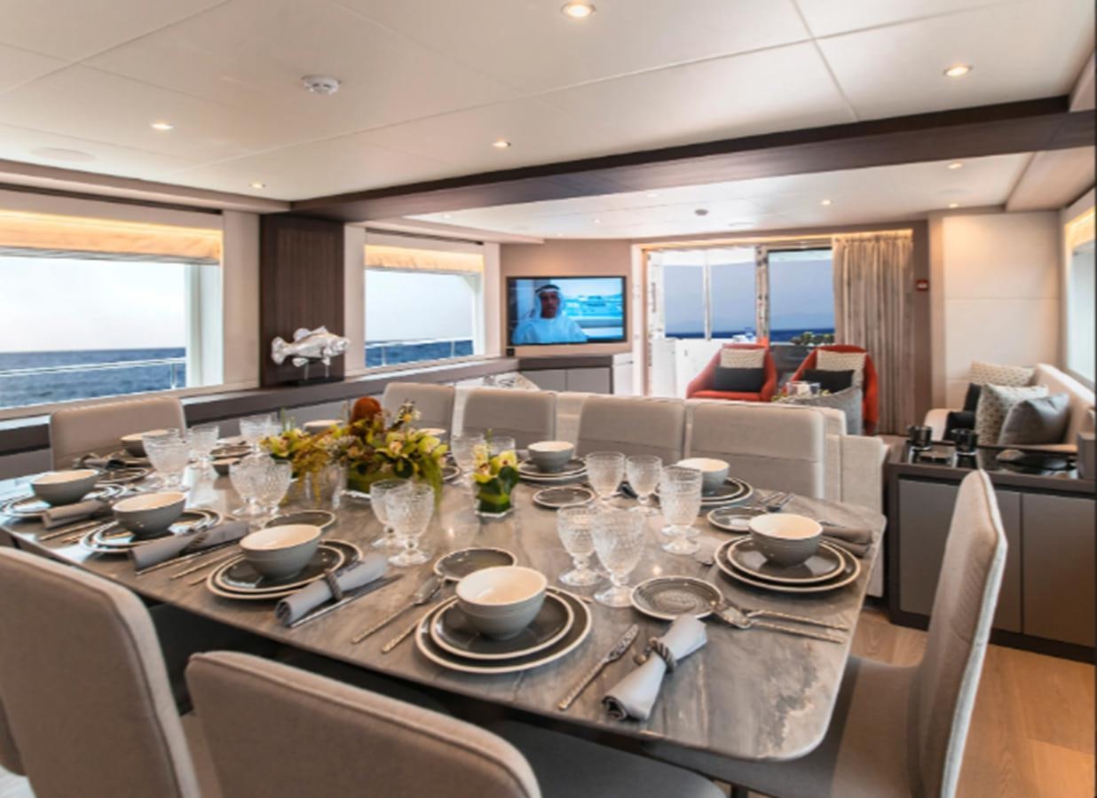 a table with plates and cups on it aboard NOMAD 95 SUV Yacht for Sale