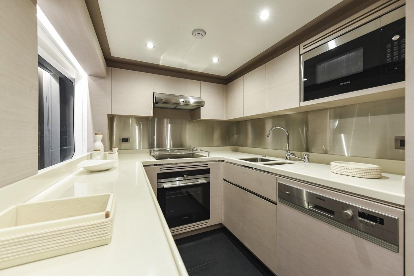 a kitchen with white cabinets aboard NOMAD 95 SUV Yacht for Sale