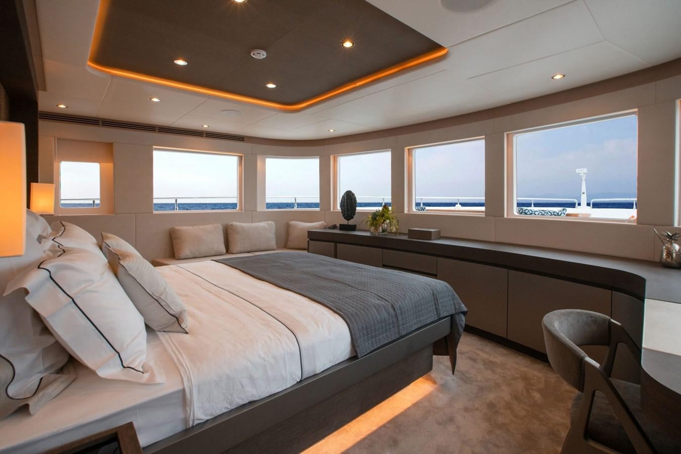 a bedroom with a bed and a desk aboard NOMAD 95 SUV Yacht for Sale