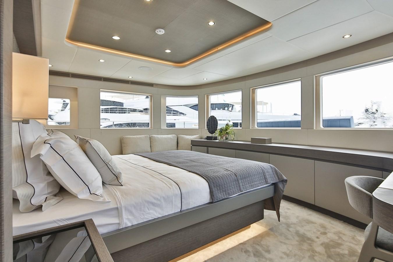a room with a bed and a lamp aboard NOMAD 95 SUV Yacht for Sale