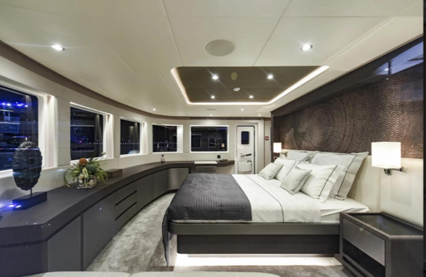 a bedroom with a bed and a desk aboard NOMAD 95 SUV Yacht for Sale