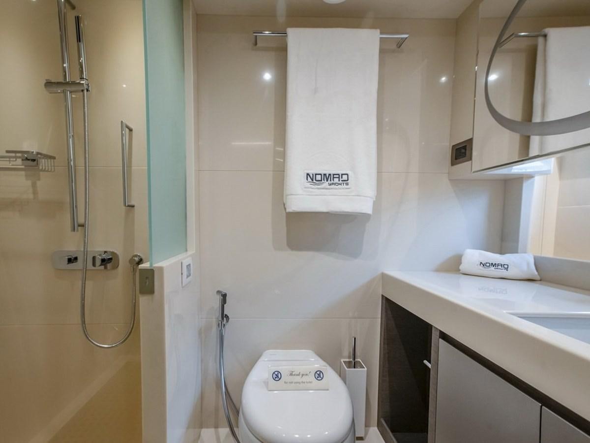 a bathroom with a toilet and a sink aboard NOMAD 95 SUV Yacht for Sale