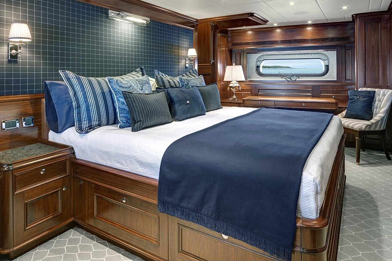 a bed with blue pillows aboard ENCORE Yacht for Sale