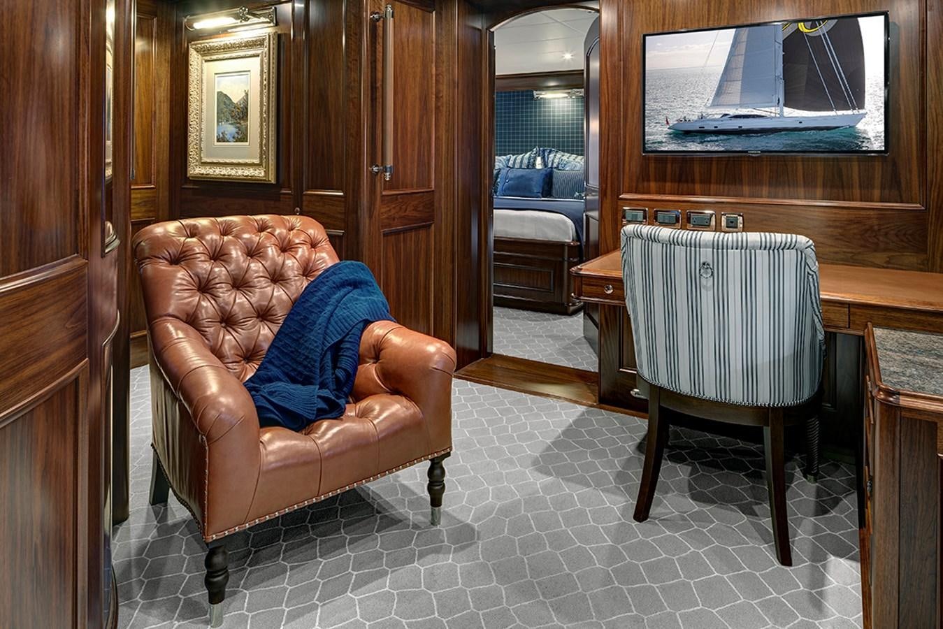 a chair and a table in a room aboard ENCORE Yacht for Sale