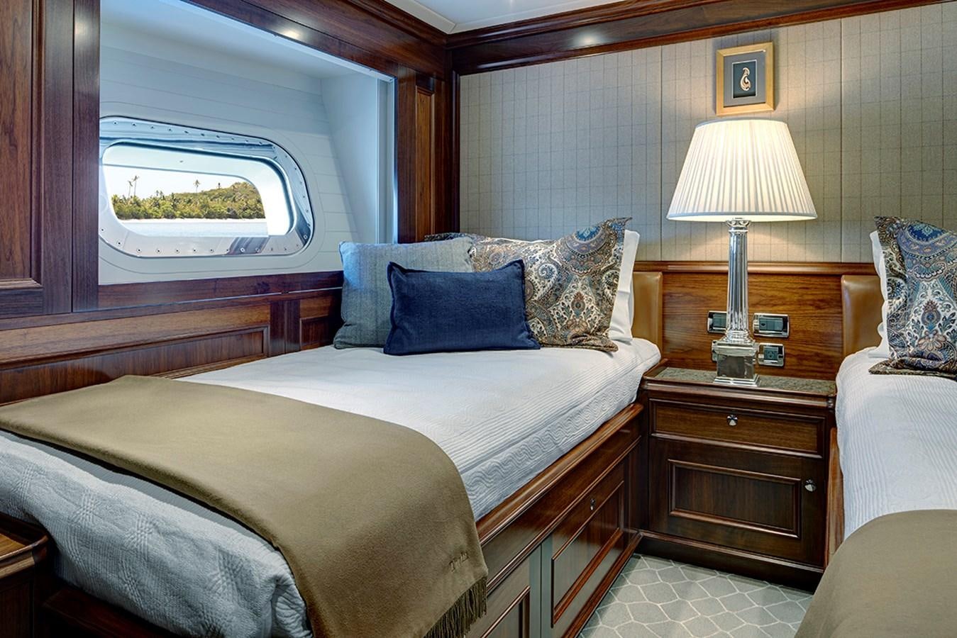 a bed with a lamp on it aboard ENCORE Yacht for Sale