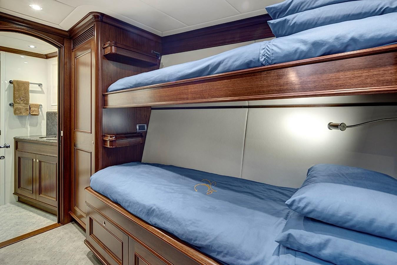 a bed with a blue comforter aboard ENCORE Yacht for Sale
