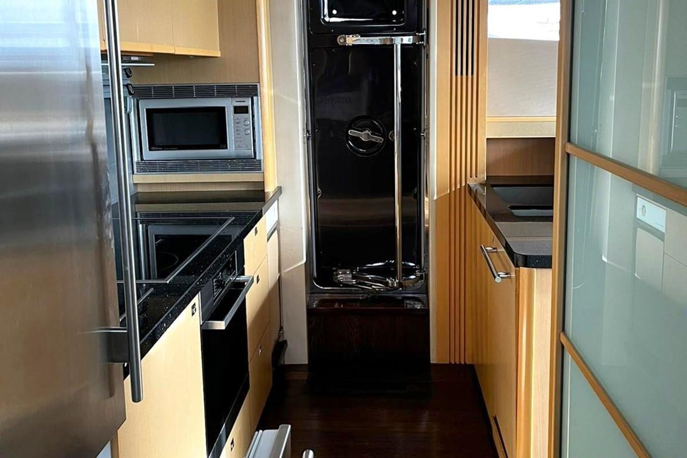 a kitchen with a black refrigerator aboard PRINCESS I Yacht for Sale