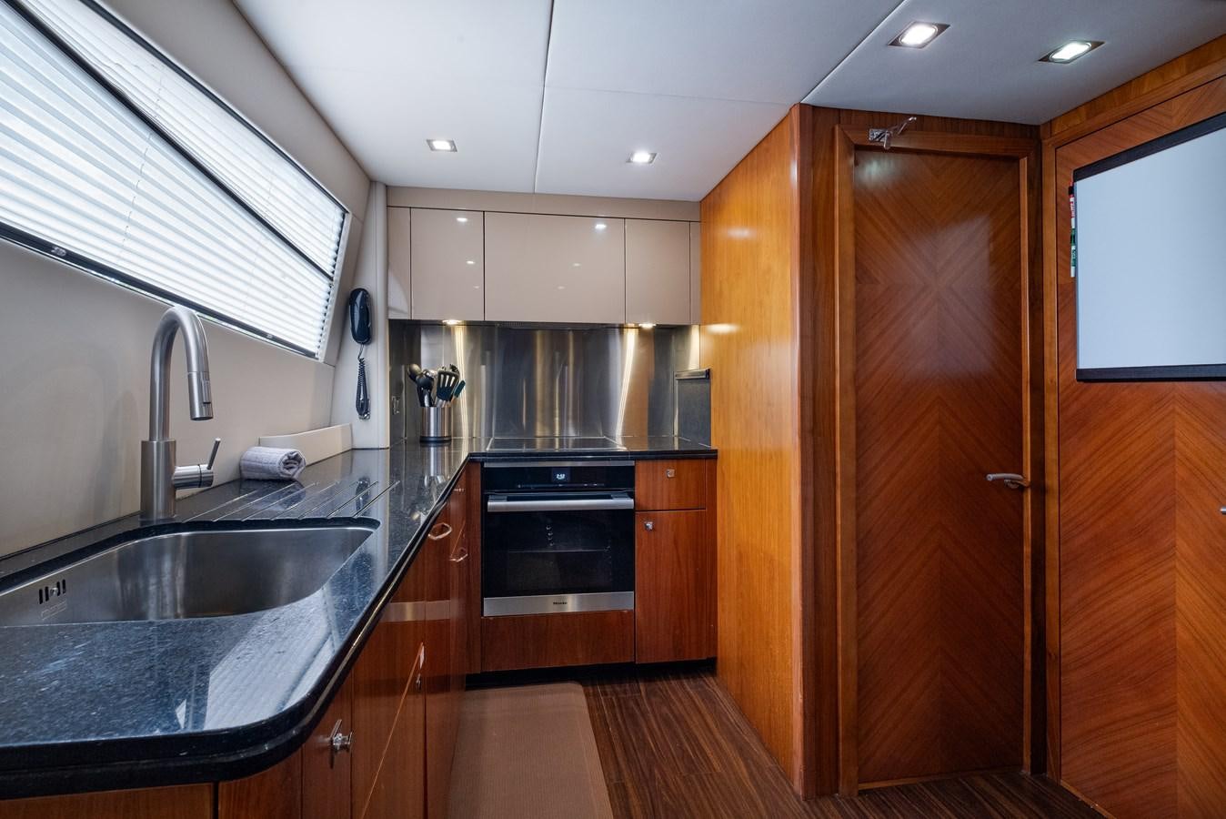 a kitchen with wooden cabinets aboard EL TIO Yacht for Sale
