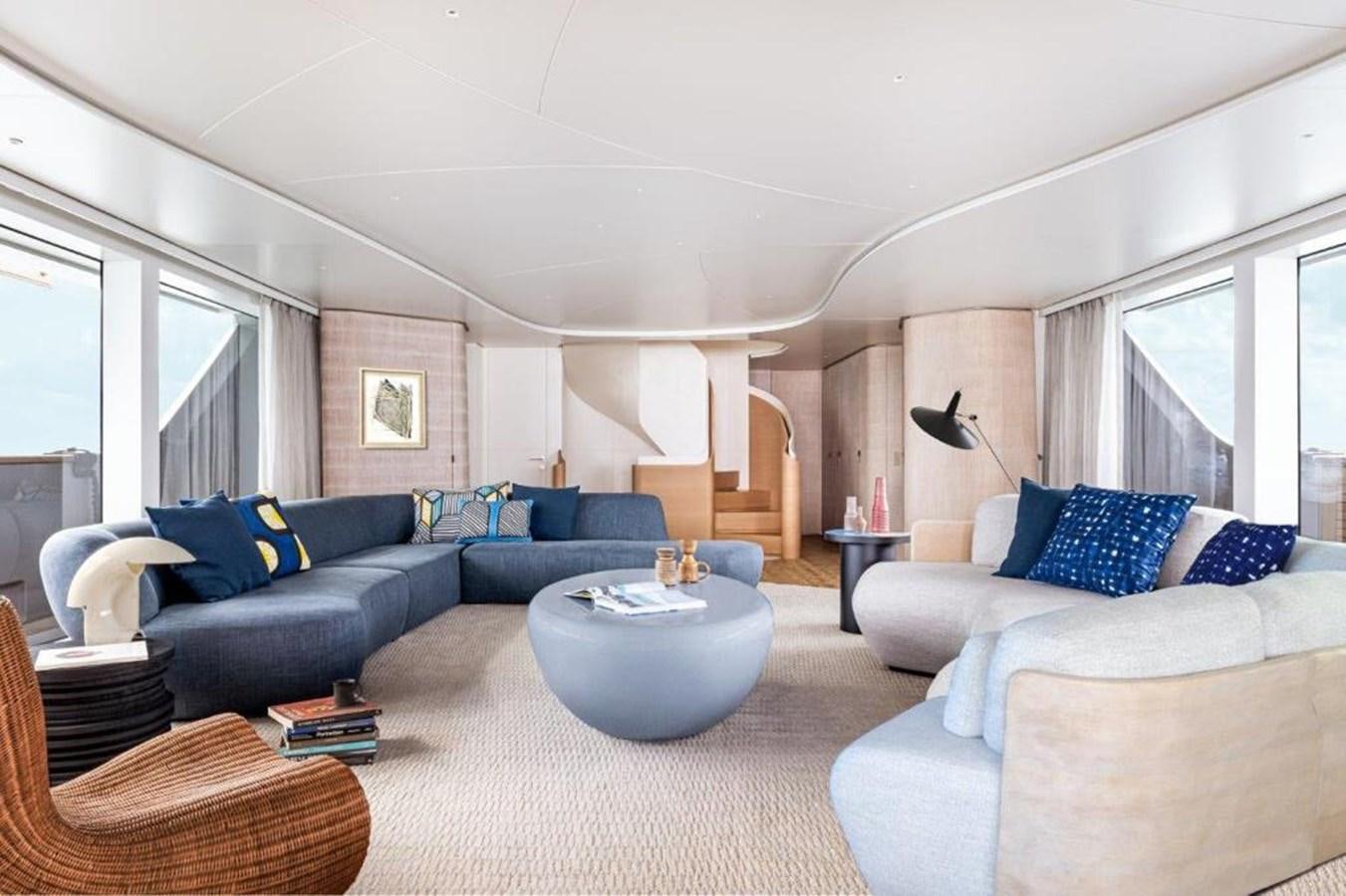 a living room with a blue couch and a coffee table aboard SANLORENZO SD118 #101 Yacht for Sale