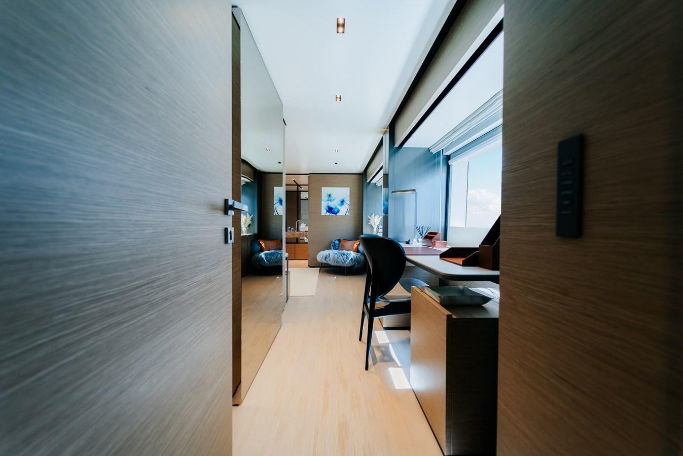 a room with a wood floor and a desk with chairs and a large window aboard COFINA Yacht for Sale