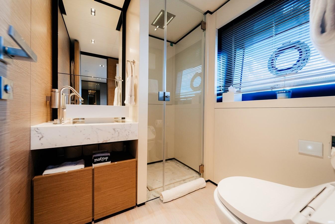a bathroom with a glass shower aboard COFINA Yacht for Sale