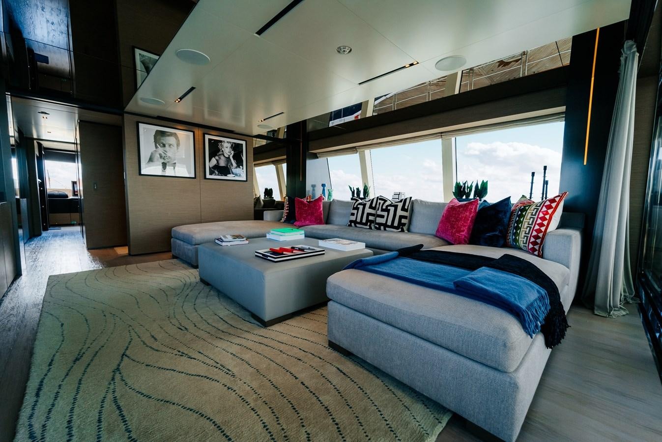 a large living room with a large blue and white rug aboard COFINA Yacht for Sale