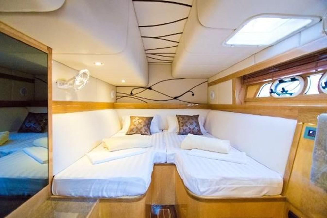 a room with beds and a window aboard 2021 HELIOTROPE NL 70 SOLAR ELECTRIC Yacht for Sale