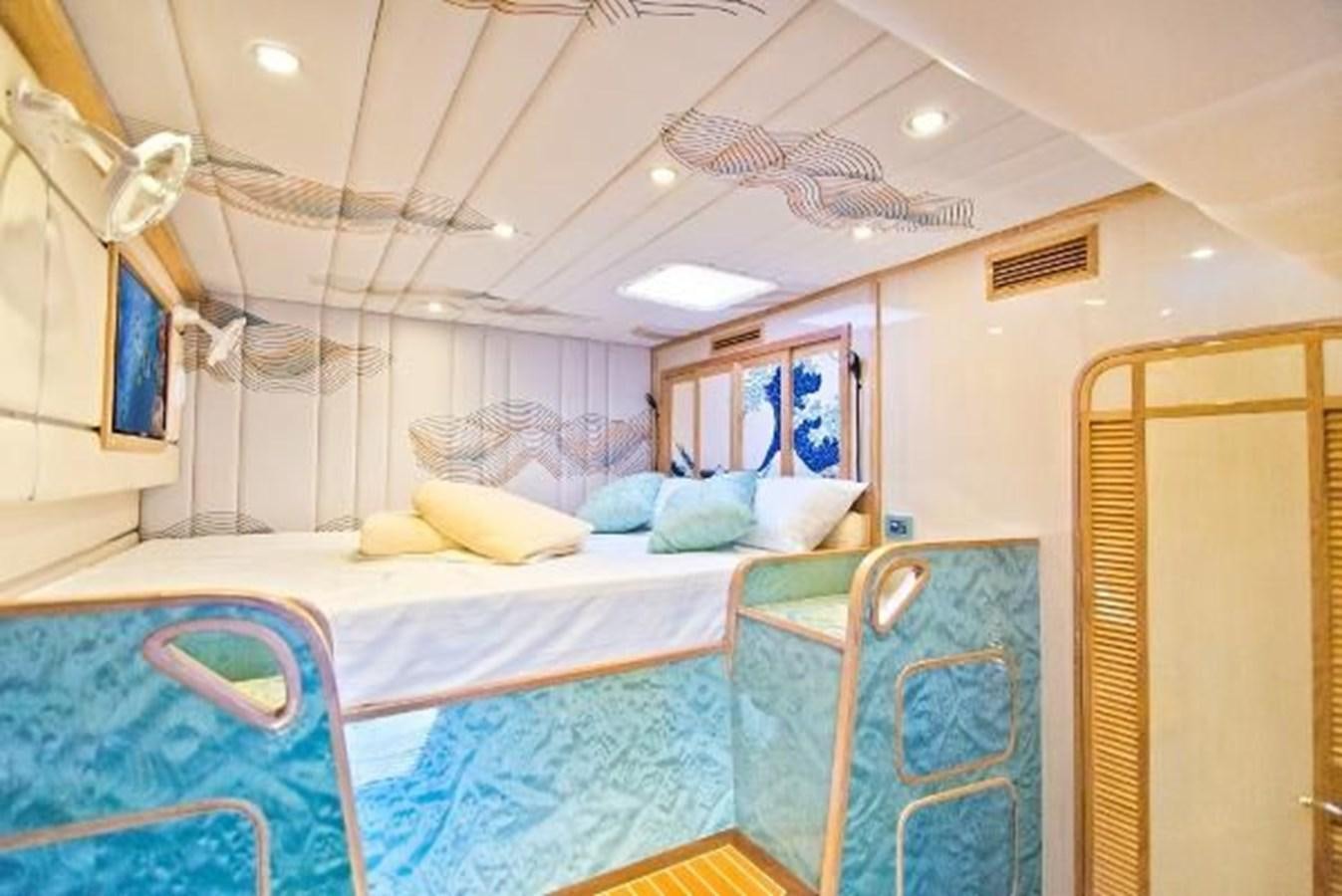 a room with beds and a fan aboard 2021 HELIOTROPE NL 70 SOLAR ELECTRIC Yacht for Sale