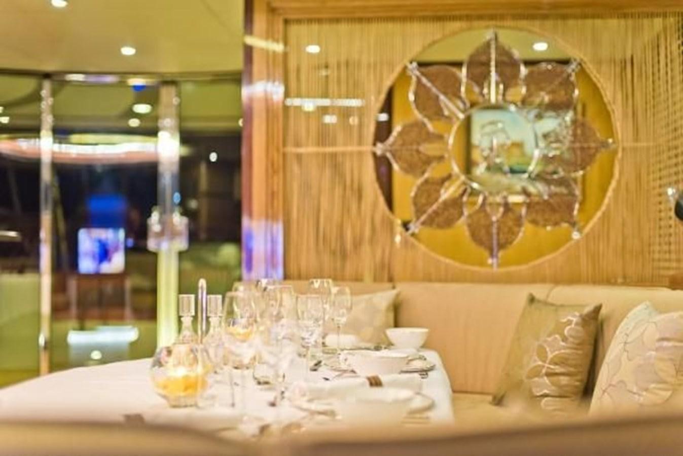 a table with a plate and glasses aboard 2021 HELIOTROPE NL 70 SOLAR ELECTRIC Yacht for Sale
