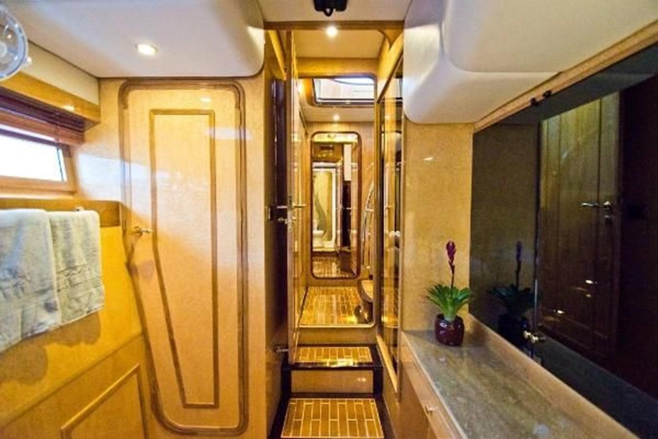 a bathroom with a wood door aboard 2021 HELIOTROPE NL 70 SOLAR ELECTRIC Yacht for Sale