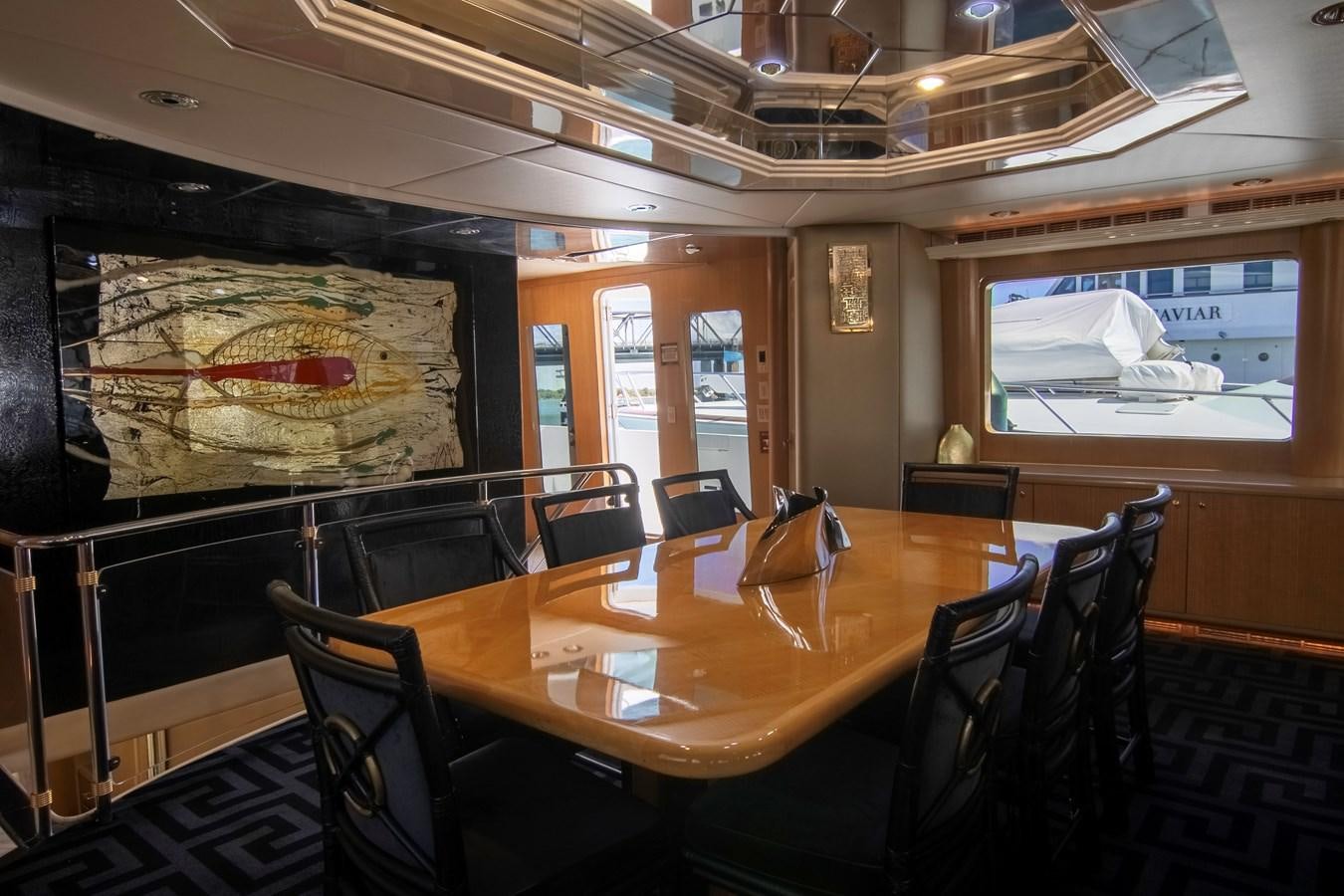 a large dining table in a large room with chairs and a large window aboard LADY AUDREY Yacht for Sale