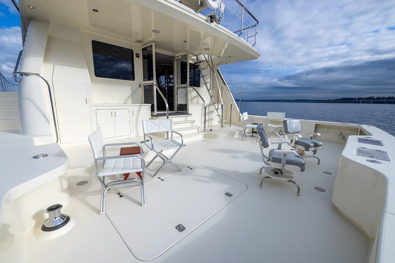 a room with a large white boat and chairs and a tv on the wall aboard WHITE LIGHTNING Yacht for Sale