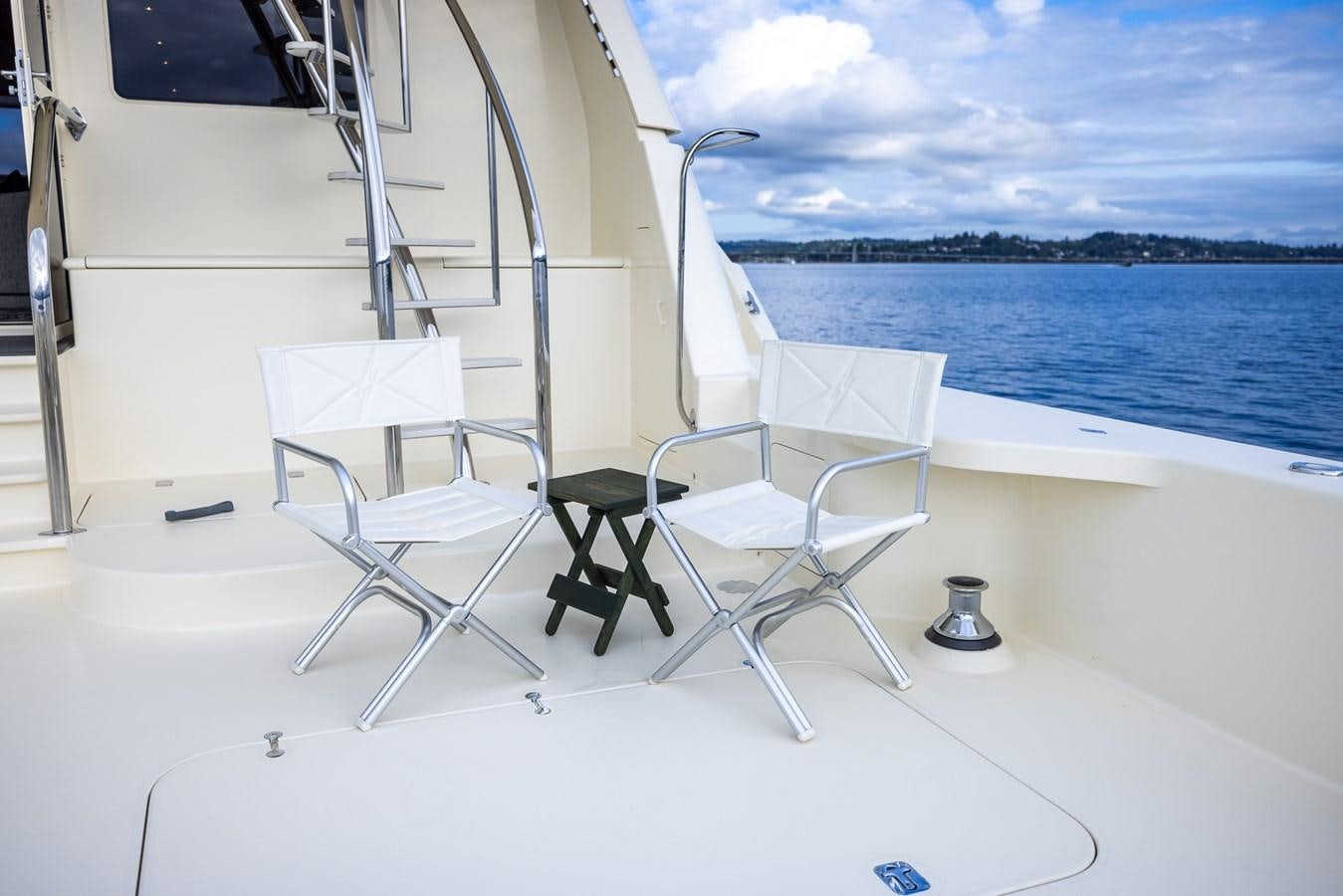a white boat with chairs on it by the water aboard WHITE LIGHTNING Yacht for Sale