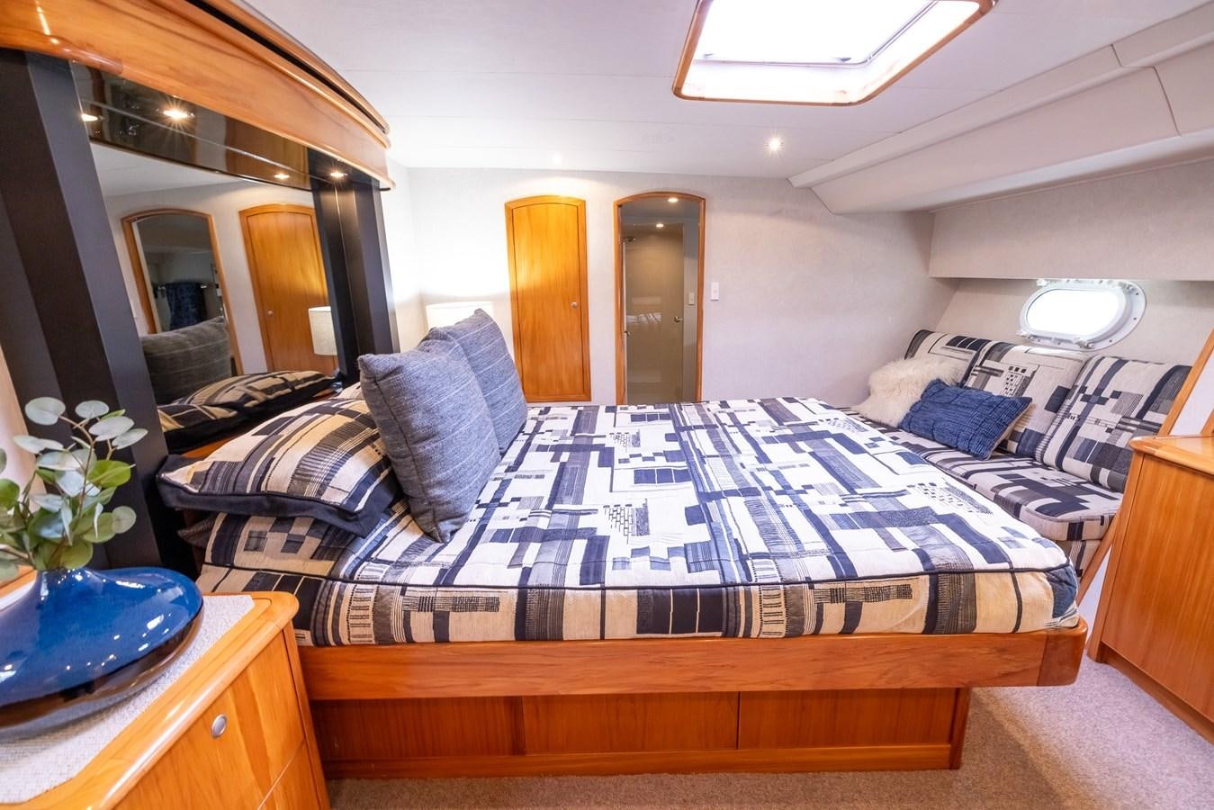a bed with a blue and white checkered blanket aboard WHITE LIGHTNING Yacht for Sale