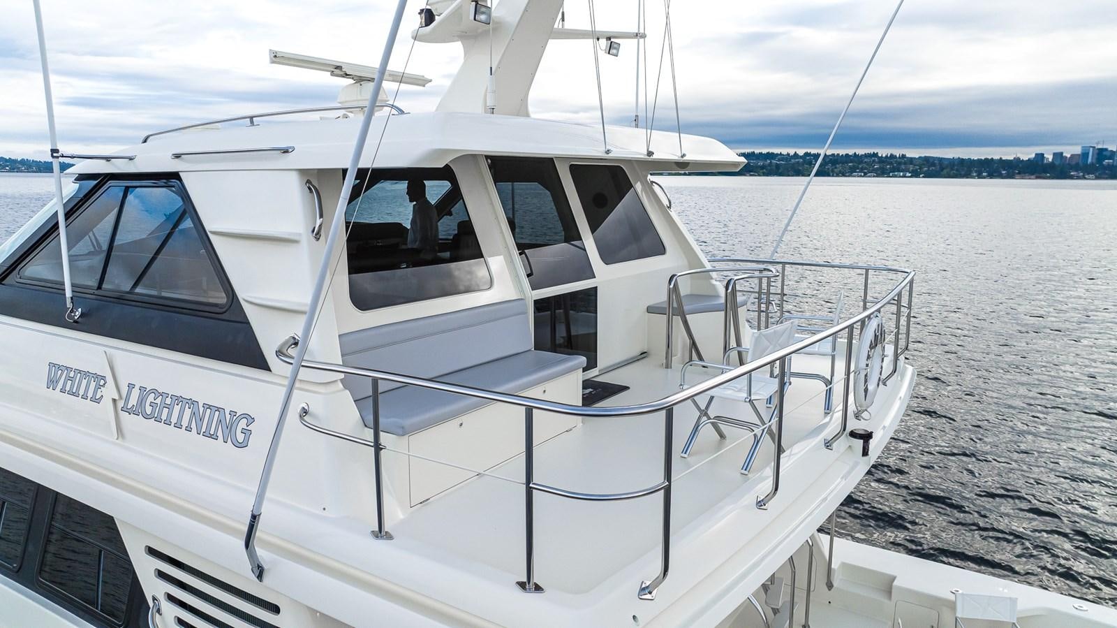 a white boat on a beach aboard WHITE LIGHTNING Yacht for Sale