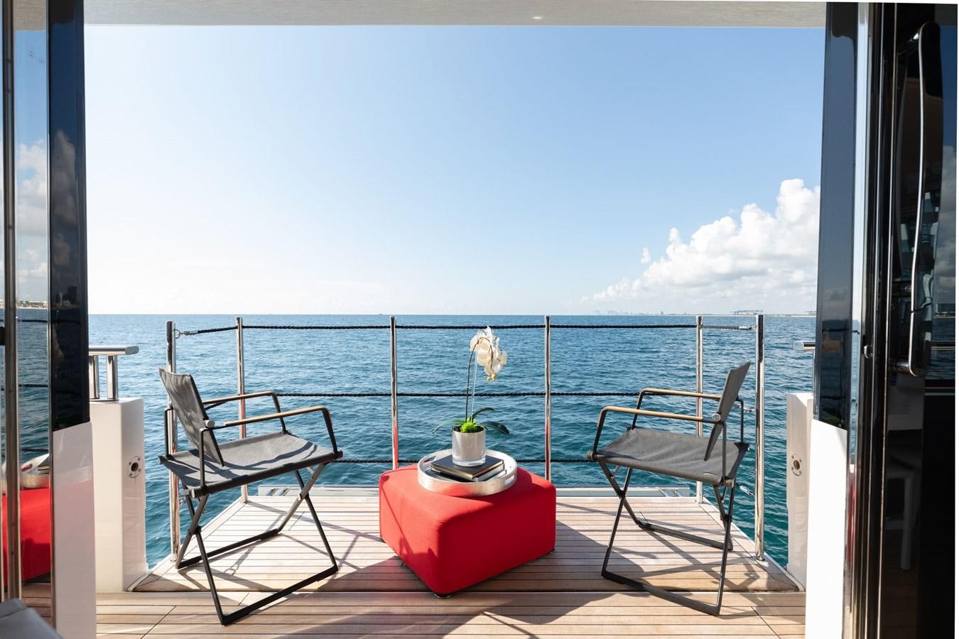 a balcony with a table and chairs on the deck aboard FIFTY SHADES Yacht for Sale