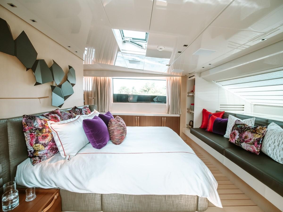 a bedroom with a bed and a window aboard FIFTY SHADES Yacht for Sale