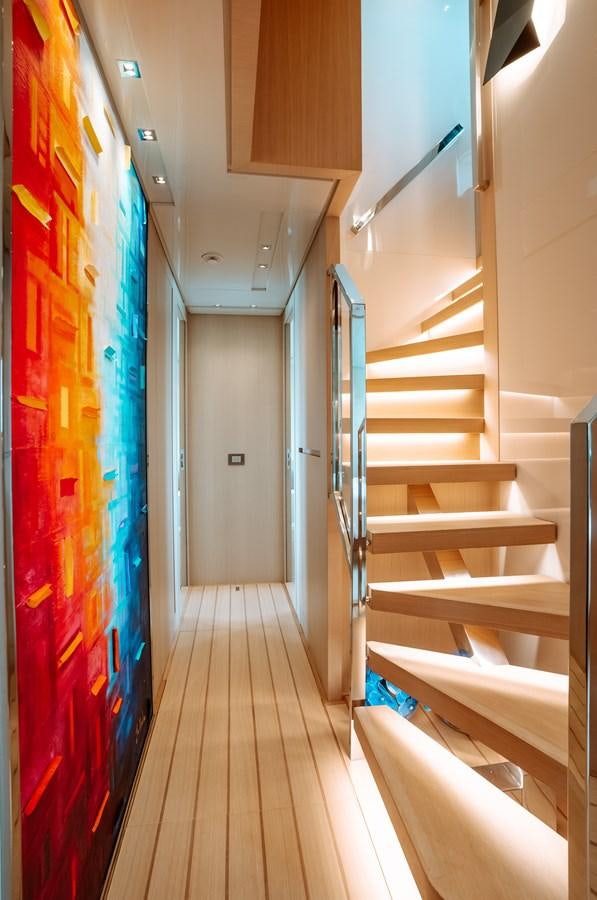 a hallway with a blue wall and a staircase aboard FIFTY SHADES Yacht for Sale