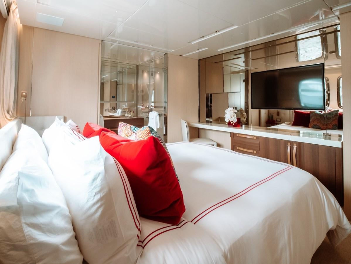 a bedroom with a bed and a tv on the wall aboard FIFTY SHADES Yacht for Sale