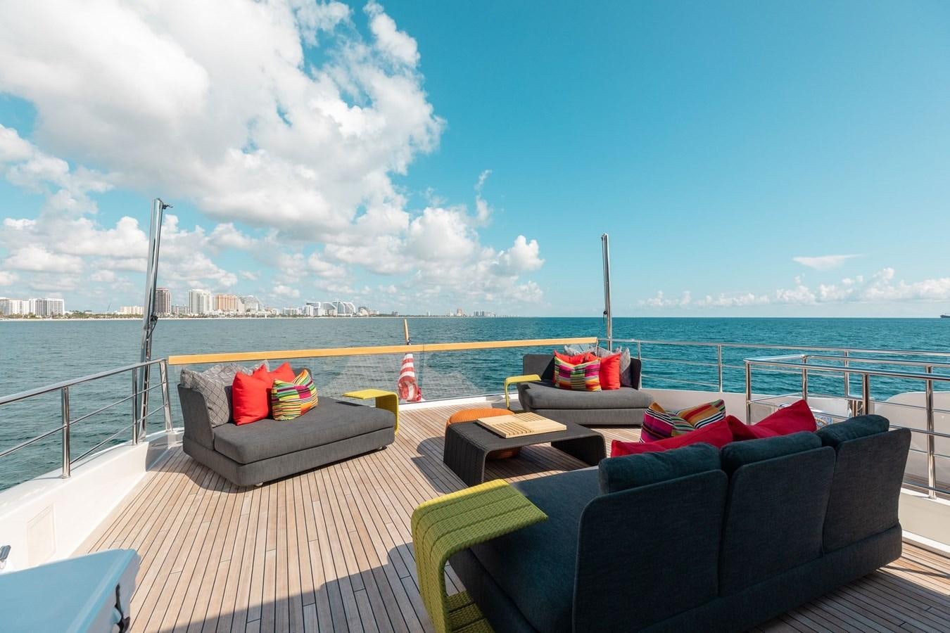 a deck with chairs and pillows on it by the water aboard FIFTY SHADES Yacht for Sale
