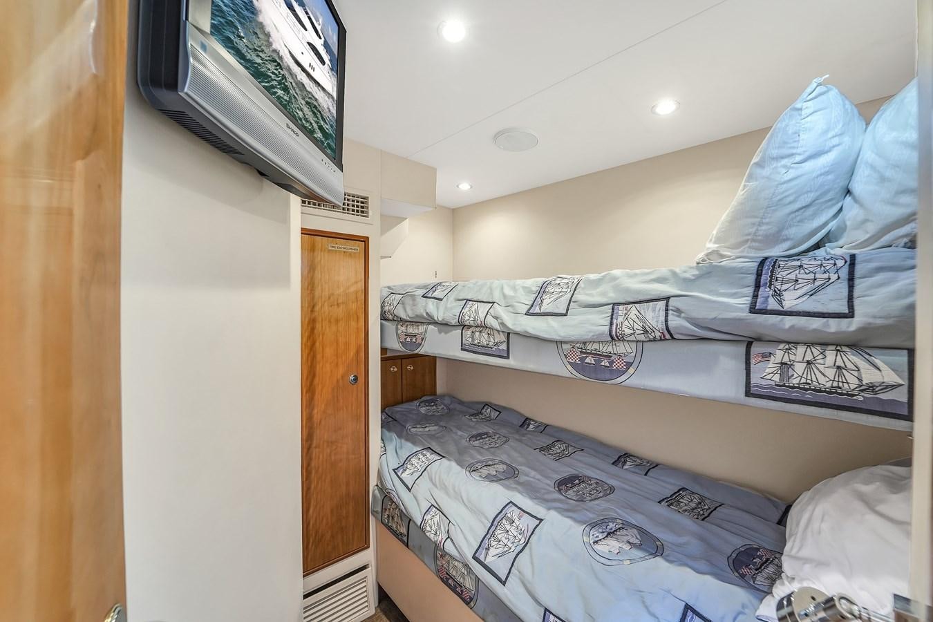 a bedroom with a bed and a television aboard HATTERAS 80 MOTOR Yacht for Sale